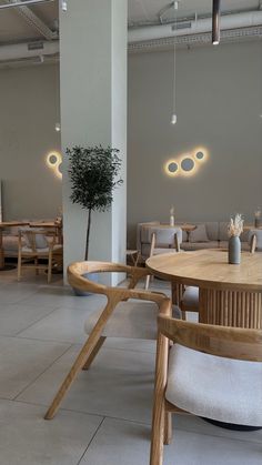 an empty room with chairs, tables and plants on the floor in front of them