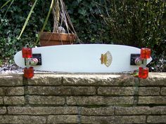 a white skateboard sitting on top of a brick wall