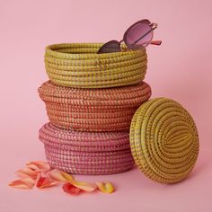 Set of three small oval boxes with lids in pink, orange and yellow colors. Each basket measures approx. 9" width, and 3" height. For storing trinkets. Woven from grass and recycled plastic ribbons using traditional coil weaving technique. Handmade by Wolof tribe women in Senegal, Africa. --------------------- The Wolof people in Senegal are known for weaving colorful baskets from locally harvested cattail stalks and strips of plastic. They weave handmade baskets of different sizes and shapes ove Cute Yellow Baskets, Colored Woven Baskets, Plastic Weave Basket, Senegal Africa, Teacher Gift Baskets, Colorful Baskets, Pink Basket, Square Baskets, Large Storage Baskets