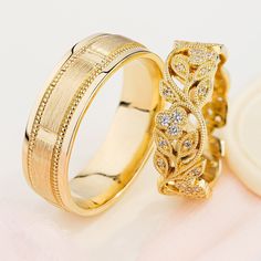 two gold wedding bands with diamonds on them