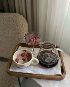 a tray with raspberries, ice cream and water on it next to a window