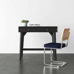 a black desk with a blue chair next to it and a potted plant on top