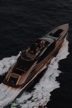 an aerial view of a large boat in the middle of the ocean with waves around it