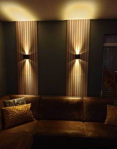 a brown couch sitting under three lights in a living room