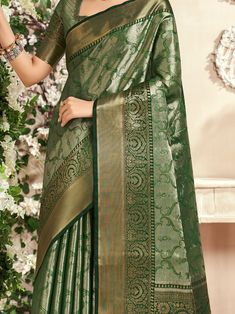 Celebrate your upcoming festivals, weddings, and occasions with the stunning "fascinating green zari weaving silk mehendi wear saree with blouse" from Ethnic Plus. This beautiful green saree is designed with intricate zari weaving work, adding a touch of elegance and sophistication to your ethnic look. The set includes a similar color silk blouse with zari weaving work, perfectly complementing the saree for a complete ensemble.
The saree is 5.50 meters in length, providing ample fabric to drape Elegant Green Pre-draped Saree For Transitional Season, Green Semi-stitched Pre-draped Saree With Meenakari, Green Bollywood Pre-draped Saree With Meenakari, Green Blouse Piece With Cutdana For Transitional Season, Transitional Green Blouse Piece With Cutdana, Green Dola Silk Pre-draped Saree For Diwali, Green Paithani Silk Pre-draped Saree With Self Design, Transitional Season Green Choli With Cutdana, Green Chanderi Choli For Transitional Season