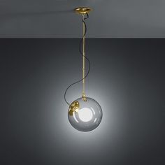 a light that is hanging from the ceiling in a dark room with grey walls and flooring