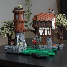 two small buildings made out of legos on a table