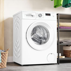 a white washing machine sitting next to a stack of towels