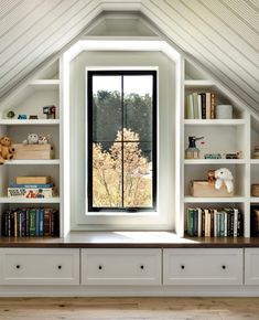 an attic bedroom with built in bookshelves and windows