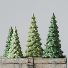 three ceramic christmas trees sitting on top of a wooden box with measurements for each one