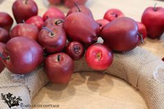 red apples are arranged on burlocked cloth