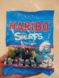 a hand holding a bag of gummy bears with the word harbo on it