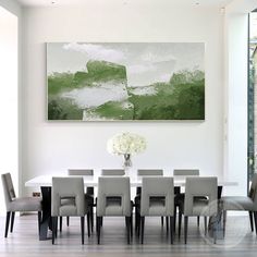 a dining room table with chairs and a large painting on the wall