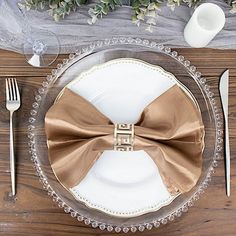 a plate with a brown bow tie on it next to silverware and utensils