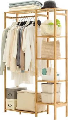 a wooden rack with clothes and baskets on it's sides, next to a white basket