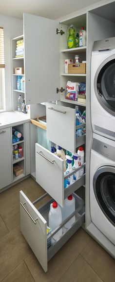 an organized kitchen with washer and dryer in the cabinet drawer, next to other appliances