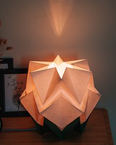 an origami lamp sitting on top of a wooden table