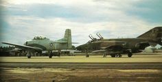 two fighter jets parked next to each other on a runway