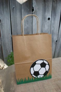 a brown paper bag with a soccer ball on it sitting on top of a table