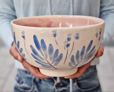 a person holding a blue and white bowl in their hands