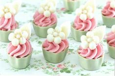 small cupcakes with pink frosting and white flowers