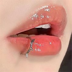 a close up of a person's tongue with piercings on it