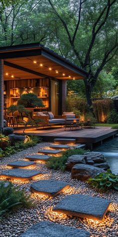 an outdoor living area is lit up with lights and stone walkways leading to the pool