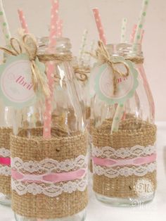 three mason jars with straw and lace on them