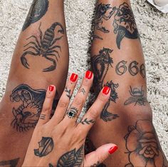 a woman's legs with tattoos on them and her hand resting on the ground