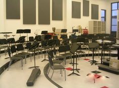 an empty room with many chairs and musical instruments on the floor next to each other