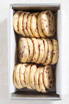 a box filled with cookies covered in frosting and cranberry toppings on top of each cookie