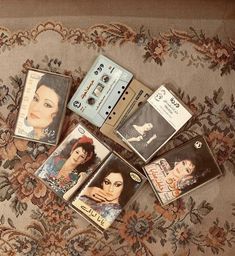 there are five cassettes on the floor next to each other and one has a woman's face