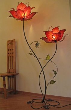 a lamp that is on top of a wooden floor next to a chair and table