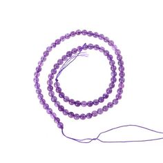 a purple beaded necklace on a white background