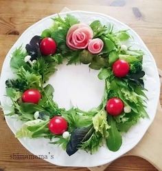 a white plate topped with a green and red wreath