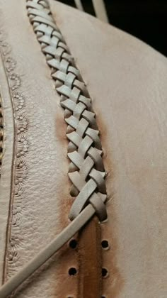 the back end of a horse's saddle with braiding and stitching on it