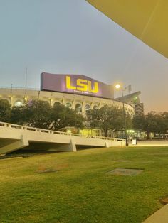 the stadium is lit up at night and it's grass covered field with benches