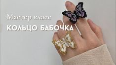 a woman's hand with two beaded butterfly rings on it, and the words matrop kaac written in russian