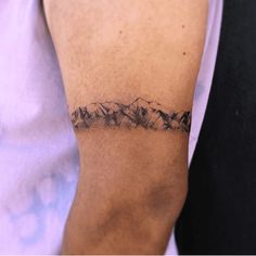 a man with a mountain tattoo on his arm