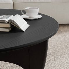 a coffee table with two books and a cup on it