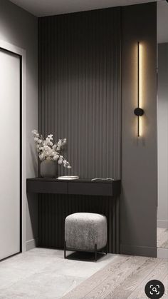 an elegant black and white room with a stool, mirror and vase on the wall