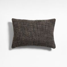 a brown and black pillow sitting on top of a white wall