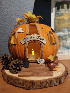 a carved pumpkin sitting on top of a wooden stand with a lit candle in it