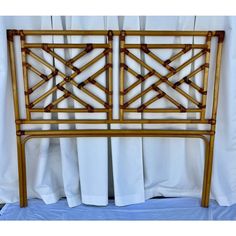 the headboard is made out of bamboo and has white linens on top of it