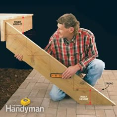 a man sitting on the ground holding a piece of wood and measuring it with a tape measure