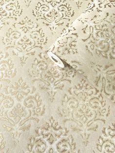 a white and beige wallpaper with an intricate design on it's surface,