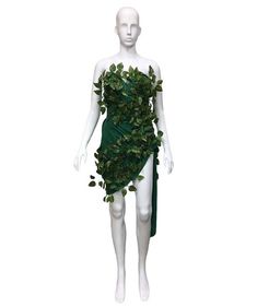 a white mannequin wearing a green dress with leaves on it's chest