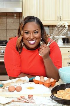 a woman is posing with eggs and whisks in front of her on the kitchen counter