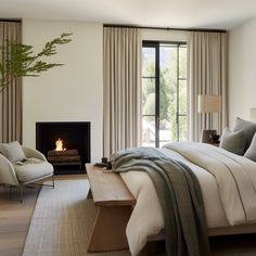 a bedroom with a bed, chair and fireplace