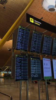 an airport terminal with many signs in front of it